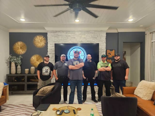 Six LTK members standing in front of a TV showing the LTK badge at the LTK house during PestWorld 2025