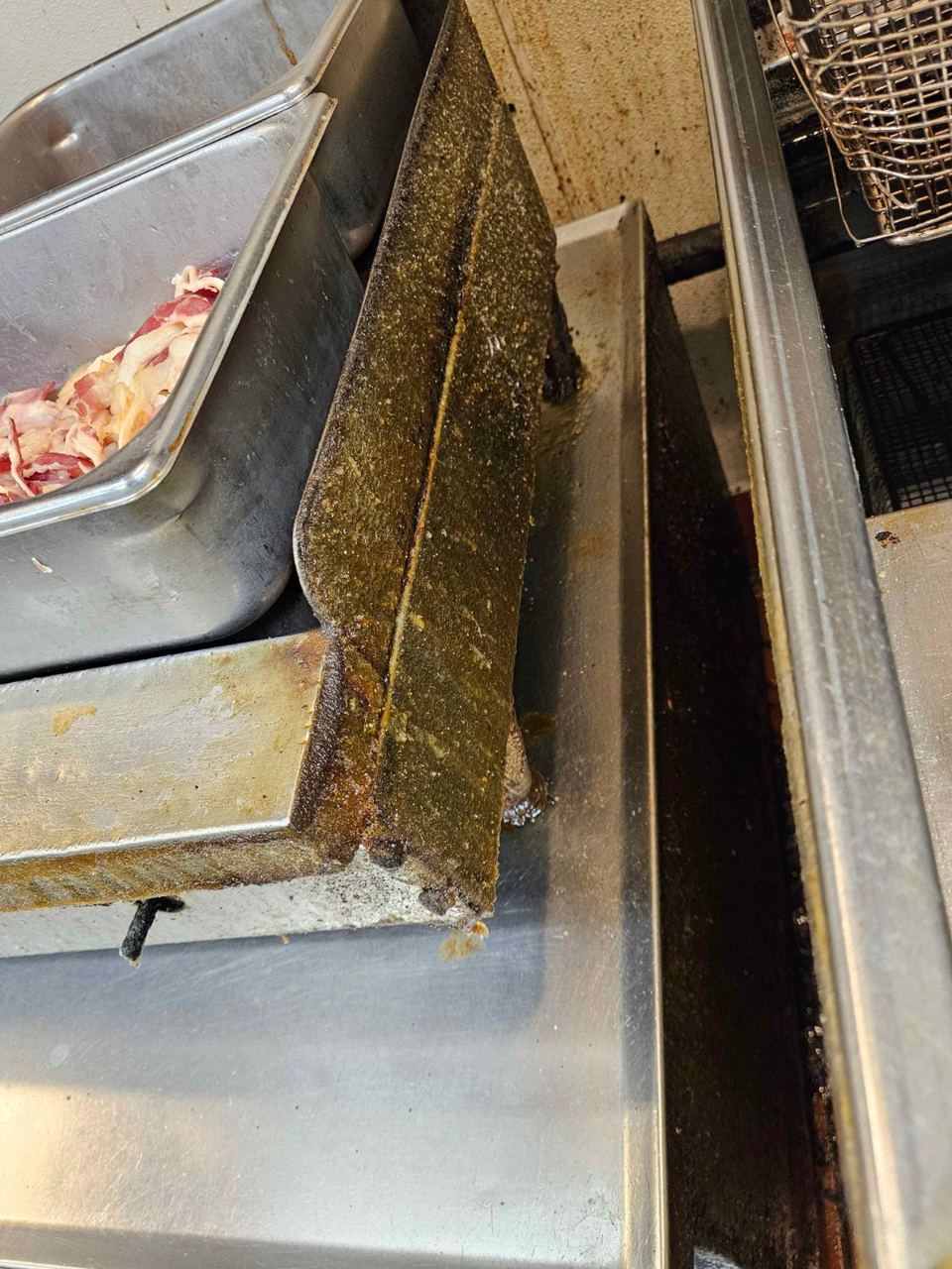 Grease built up along the edge of a stainless cooking station
